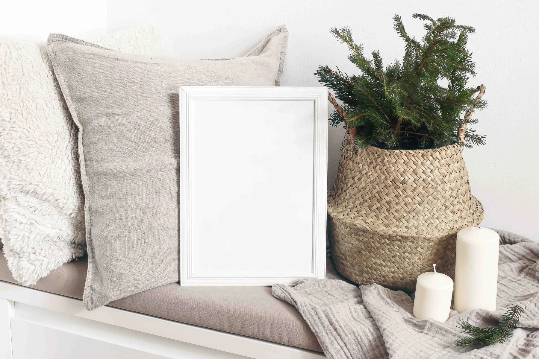 Naama - Raumaustatter, Möbel, Gardinen - Weißer, leerer Holzrahmen mit Weihnachtsbaum, Kerzen, Leinenkissen und karierter Decke auf einer weißen Bank. Poster-Produktdesign. Skandinavische Wohndekoration, nordisches Design. Winterliches Festtagskonzept.